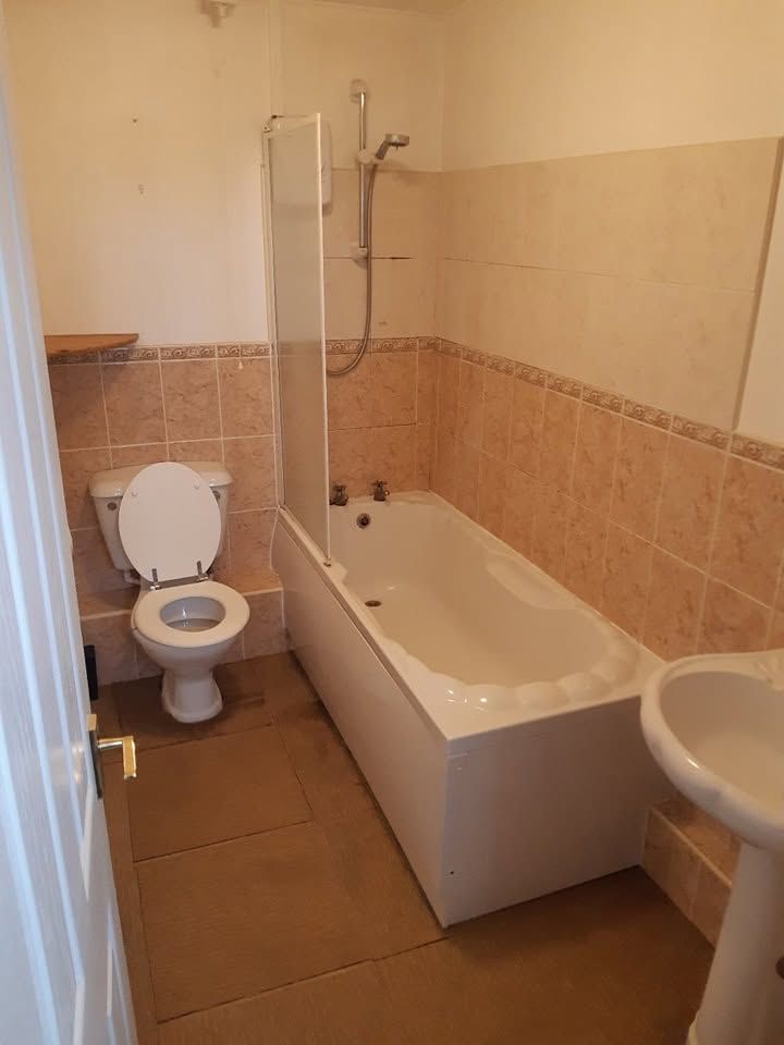 Bathroom before renovation with peach tiles and old suite