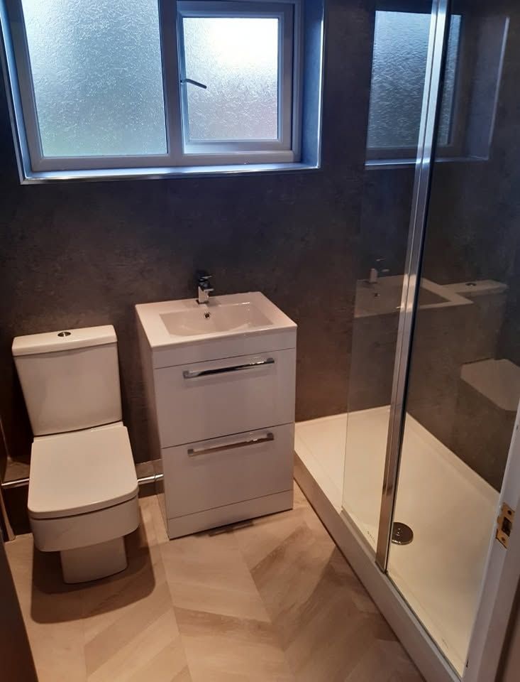 White fitted bathroom with hexagonal black floor tiles