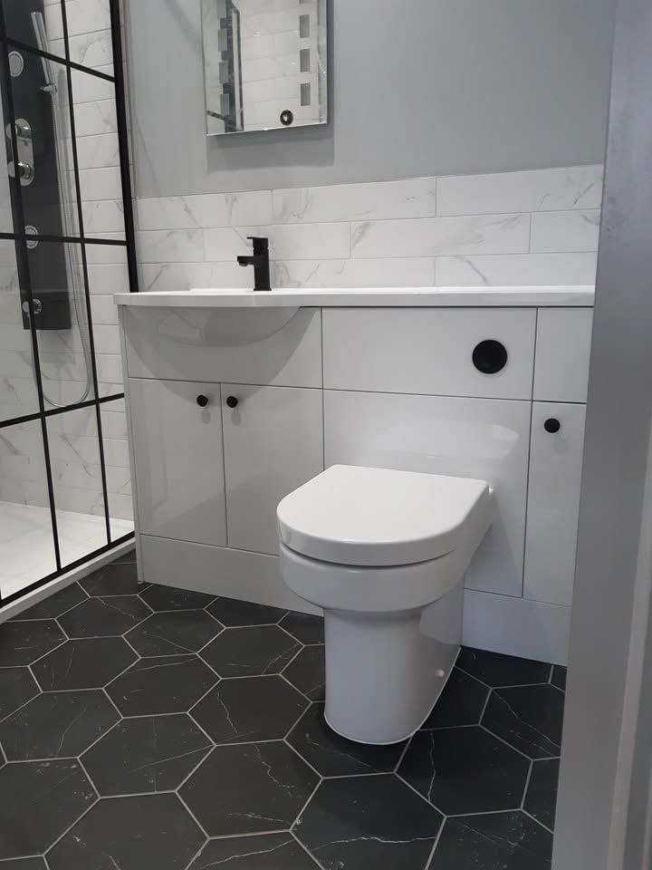 Wetroom with grey wall tiles and floor drain